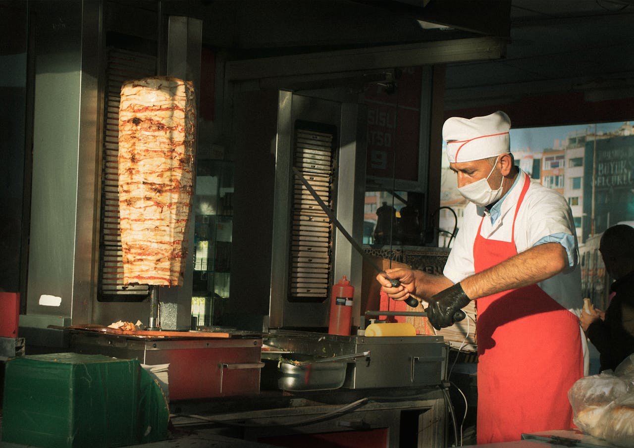 A chef slicing traditional Turkish kebab at a vibrant Istanbul street food stall.